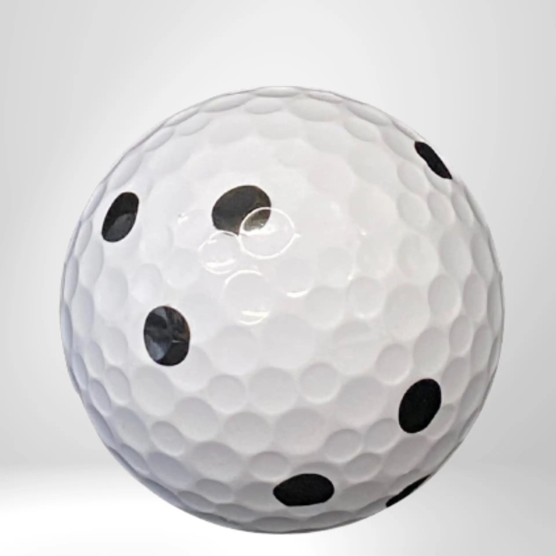 Weißer Golfball mit schwarzen Punkten auf neutralem Hintergrund, Golfzubehör Produktfoto