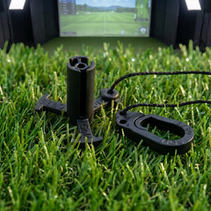 Sebo Golf Simulator Tee in Schwarz auf Kunstrasen platziert.