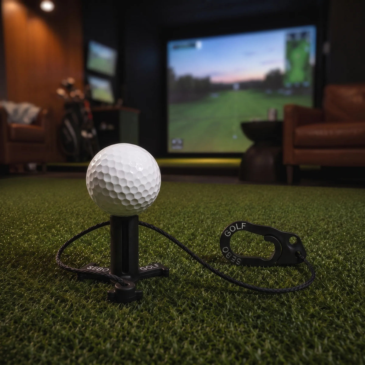 Sebo Golf Simulator Tee mit Golfball auf einem Kunstrasenboden vor einem Golf-Simulator.
