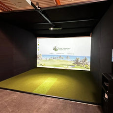 Indoor Golf Simulator mit Leinwand, grünem Kunstrasen und Computer im Golfraum