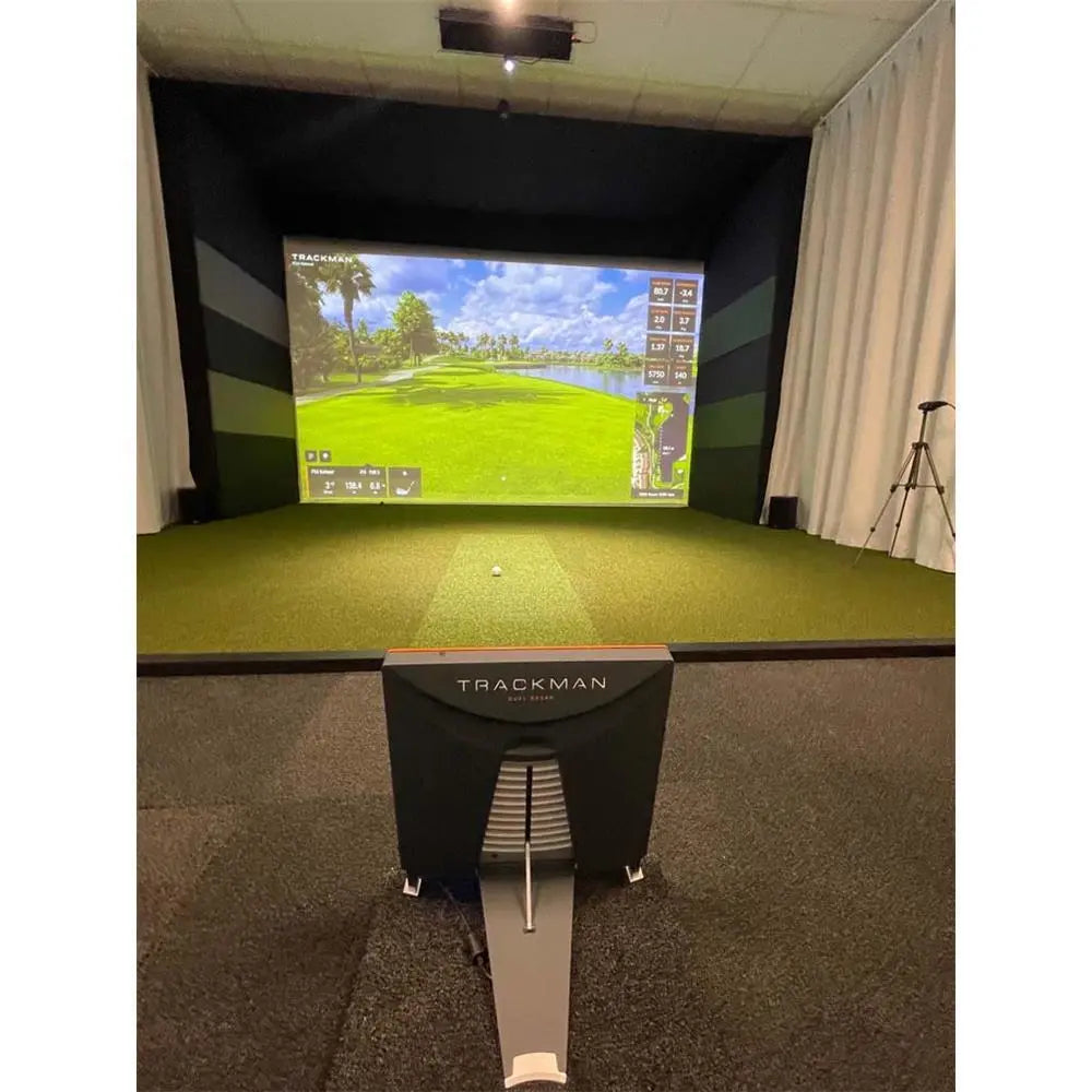 Moderner Golf Simulator mit Trackman Gerät, großem Bildschirm und grünem Indoor-Rasen