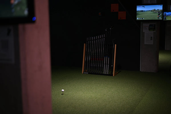Golf Schlägerständer aus Eiche in Schwarz mit Golfschlägern auf Indoor-Kunstrasen