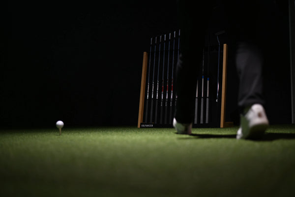 Golf Schlägerregal aus Eiche schwarz mit Golfschlägern, Golfer auf Kunstrasen, Golfball auf Tee