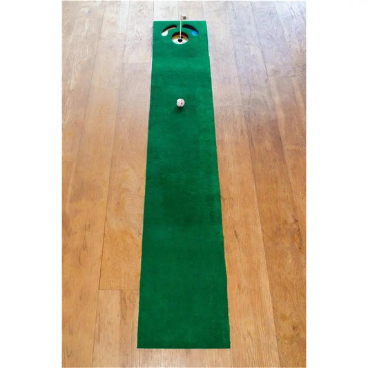 Grüne Putting-Matte für Indoor Golftraining mit Golfball und Zielloch auf Holzfußboden