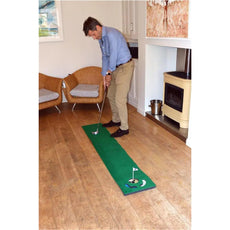 Mann spielt Golf auf Putting-Matte im Wohnzimmer, Indoor Golf Training, Putting Übung