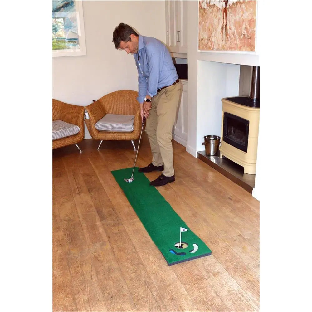 Mann spielt Golf auf Putting-Matte im Wohnzimmer, Indoor Golf Training, Putting Übung