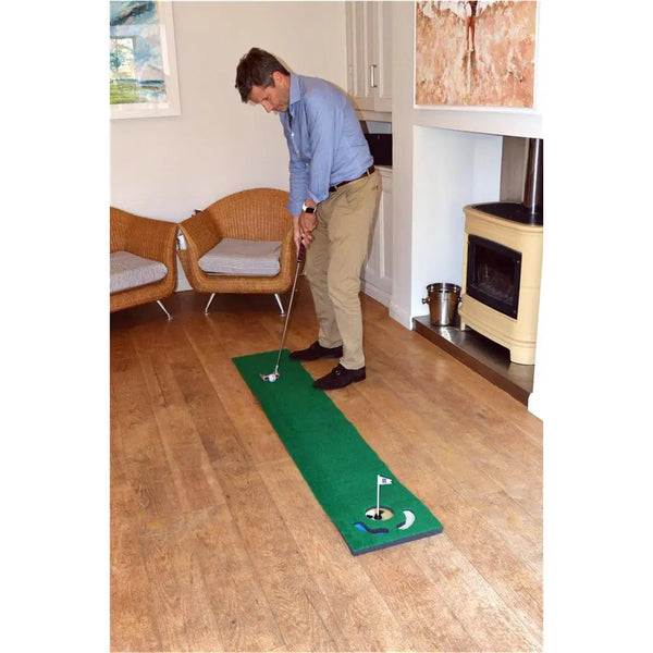 Mann spielt Golf auf Putting-Matte im Wohnzimmer, Indoor Golf Training, Putting Übung