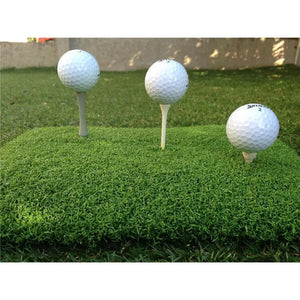 Drei Golfbälle auf Abschlagmatte mit verschiedenen Tees, ideal für Golftraining und Indoor-Golf.