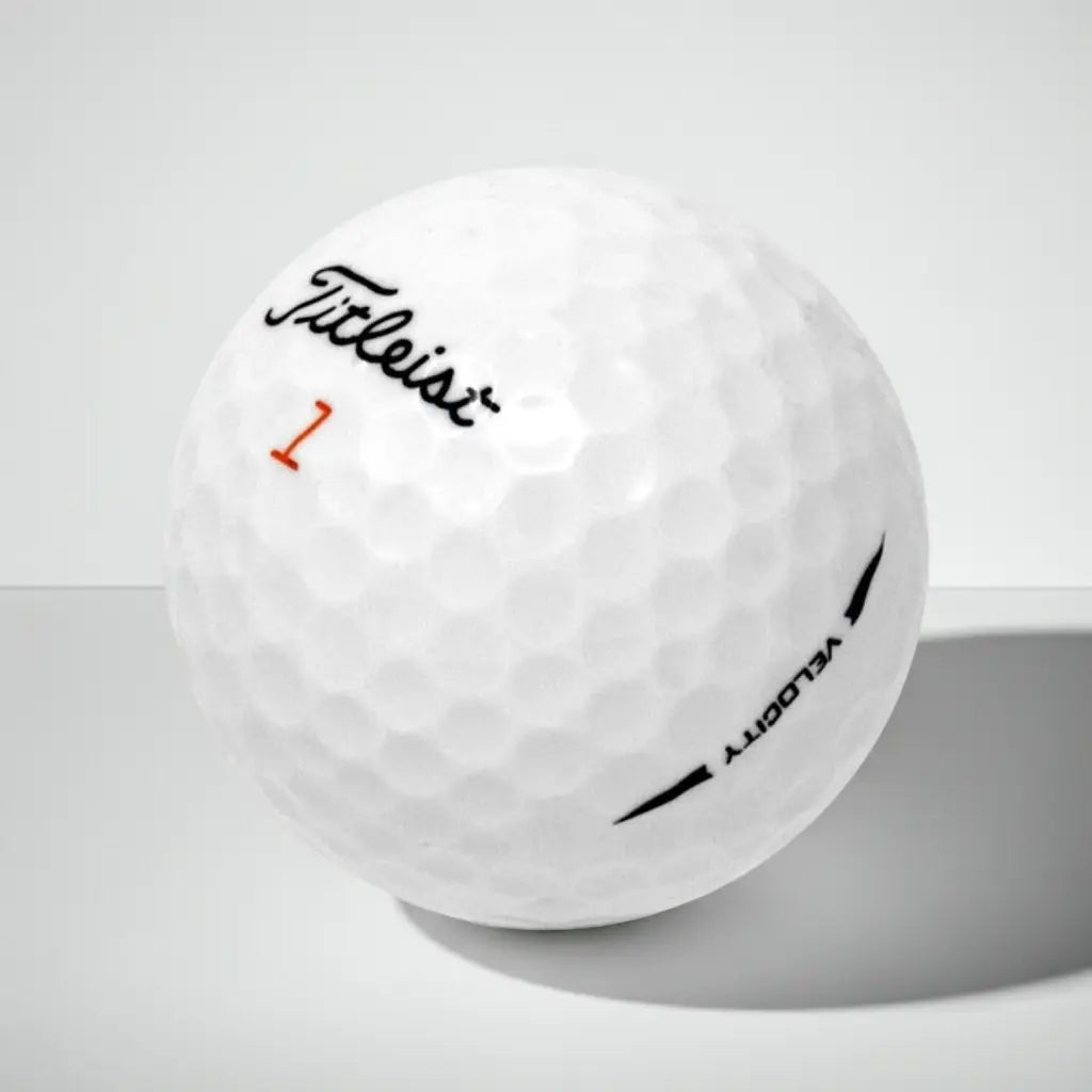 Weißer Golfball mit Markenlogo, Modellnummer und Text auf strukturierter Oberfläche, Studiohintergrund