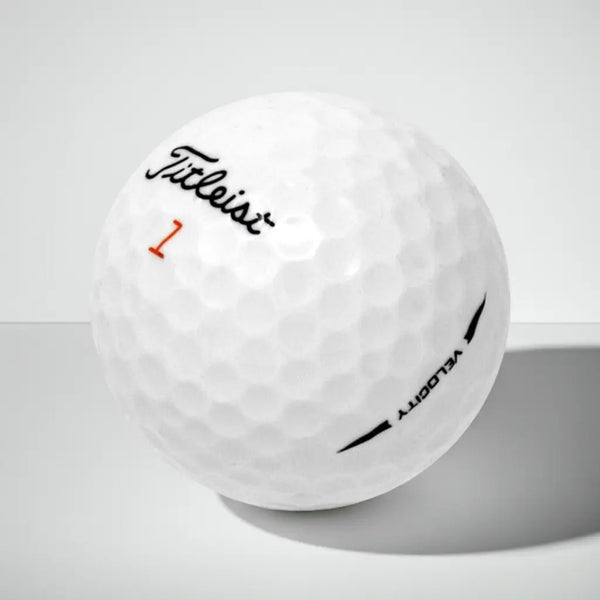Weißer Golfball mit Markenlogo, Modellnummer und Text auf strukturierter Oberfläche, Studiohintergrund