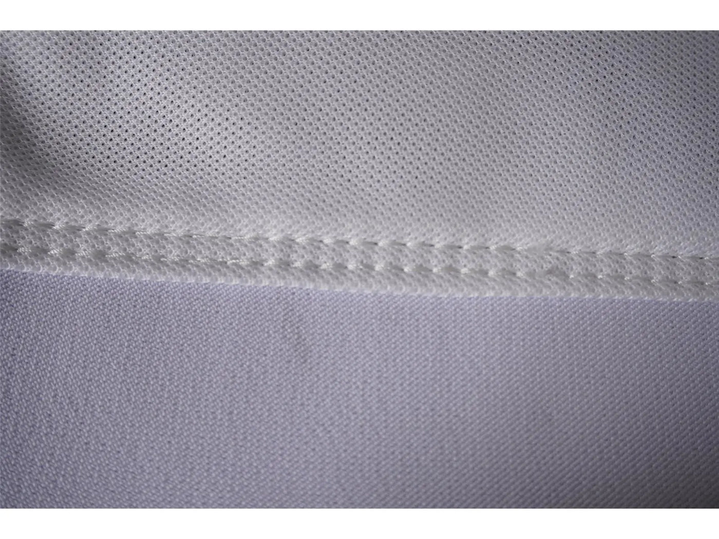 Nahaufnahme von weißem Golftextil mit feiner Naht und hochwertiger Stoffstruktur
