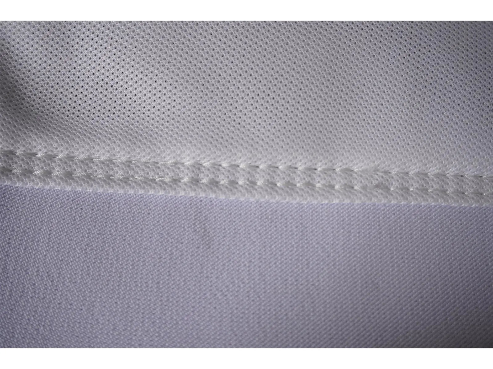 Nahaufnahme von weißem Golftextil mit feiner Naht und hochwertiger Stoffstruktur