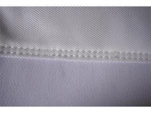 Nahaufnahme von weißem Golftextil mit feiner Naht und hochwertiger Stoffstruktur