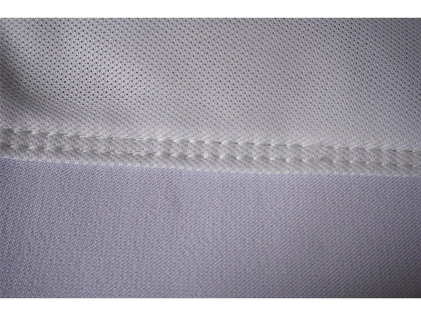 Nahaufnahme von weißem Golftextil mit feiner Naht und hochwertiger Stoffstruktur