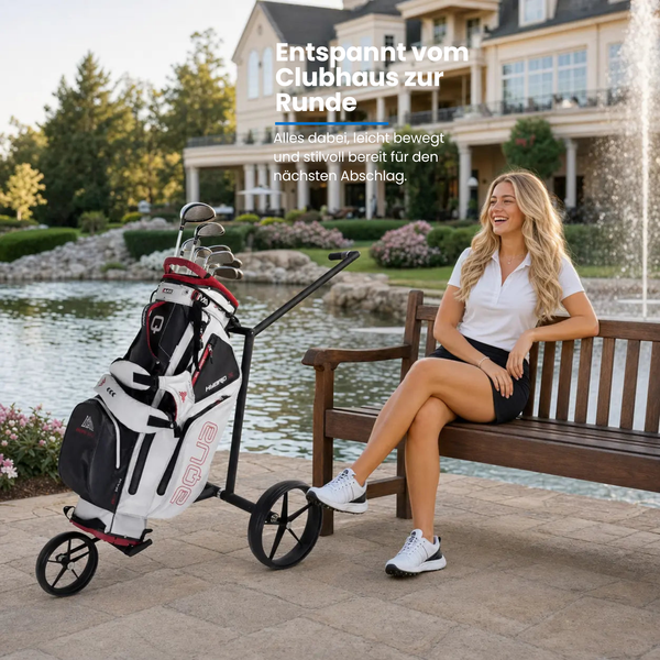 Big Max e-Lite 3 Rad Elektro Trolley mit Golftasche und Golferin am Teich im Hintergrund.