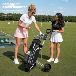 Big Max Basic - 2 Rad Push Trolley mit zwei Golfspielerinnen auf einem Übungsplatz.