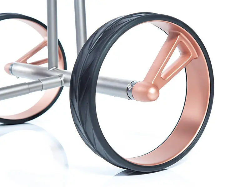 Detailansicht modernes Golf Trolley Rad mit Roségold Felge und schwarzem Reifen